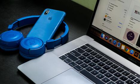 Macbook Pro Beside Blue Wireless Headphones 1113804